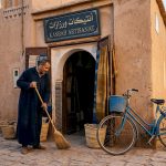 Shopkeeper sweeping doorway of Ouarzazate kasbah
